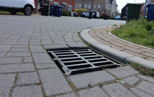 A grid fixed into a road on a housing estate.