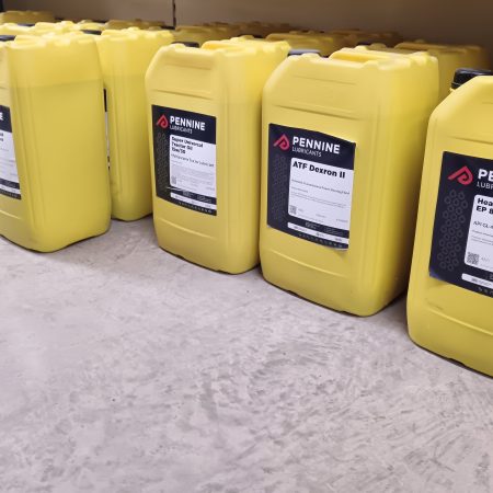 A row of 25-litre yellow containers of oil by Pennine Lubricants.