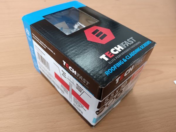 A black, red and blue box containing roofing and cladding screws by Tech Fast.